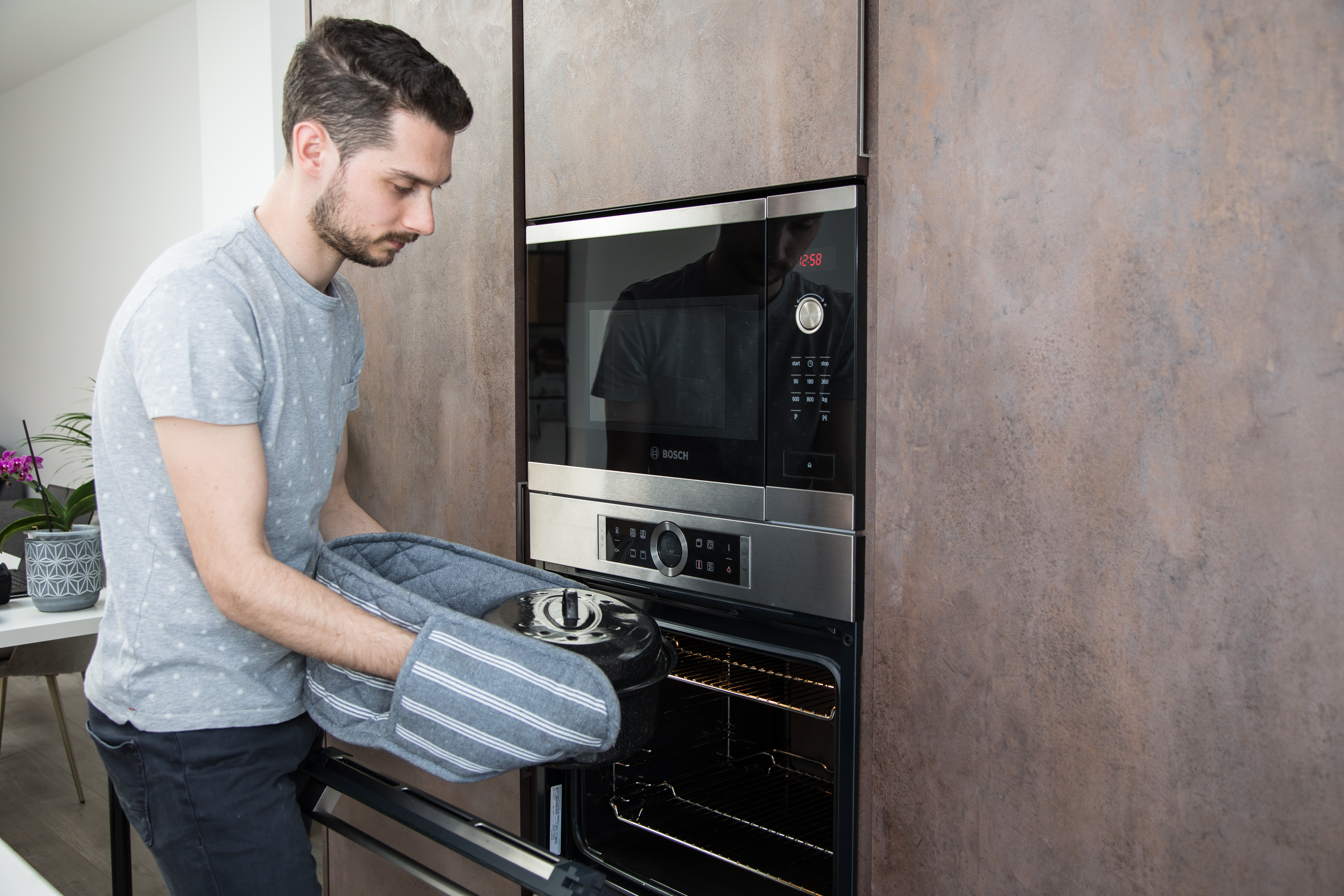 Man taking pot out of the oven